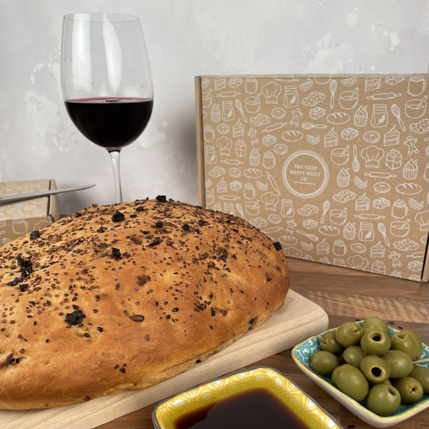 Finished loaf with dip, olives and a glass of wine